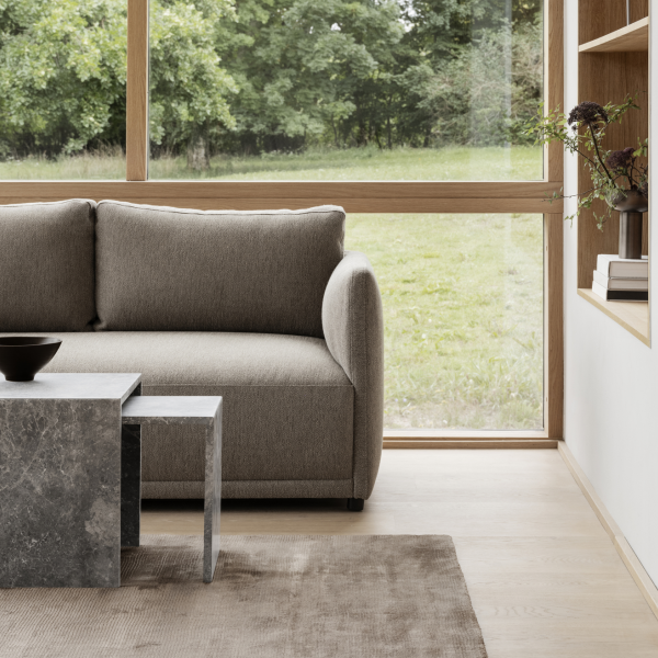 Modern living room featuring a gray sofa and minimalist coffee table by large windows.