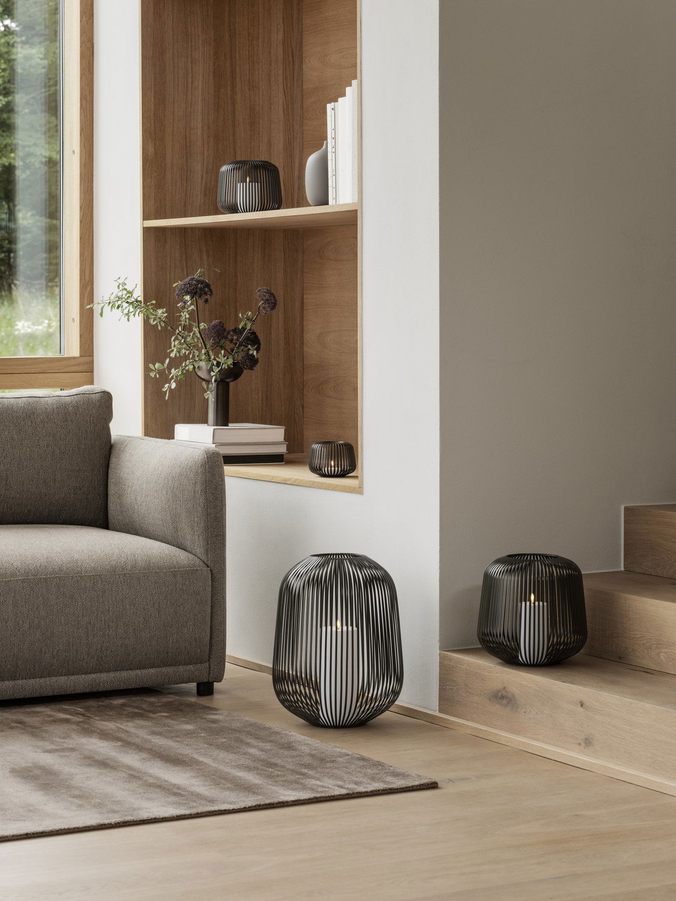 Modern living room with stylish black wire lamps and minimalist furniture accents.