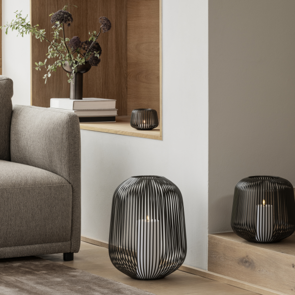 Stylische schwarze Drahtlaternen beleuchten eine gemütliche Wohnzimmerumgebung mit modernem Dekor.