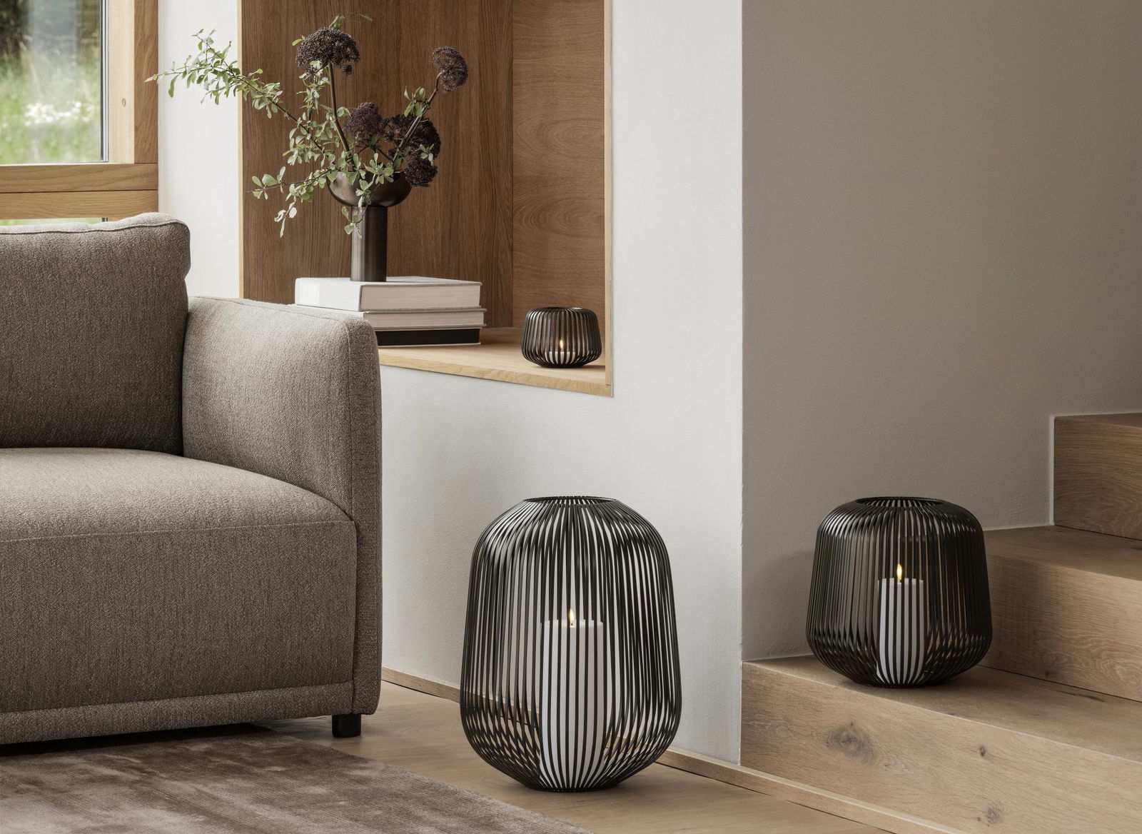 Stylische schwarze Drahtlaternen beleuchten eine gemütliche Wohnzimmerumgebung mit modernem Dekor.
