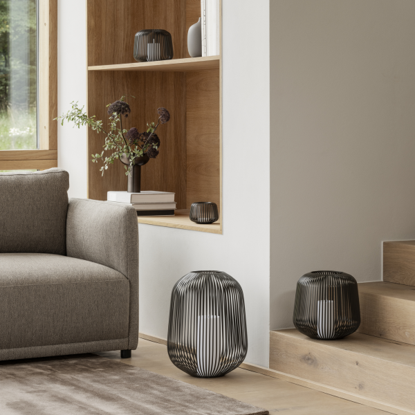 Modern living room with stylish wire lamps and neutral furnishings on wooden decor.