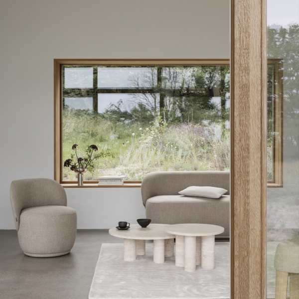 Modernes Wohnzimmer mit gemütlicher Möbel und Blick auf die grüne Landschaft draußen.