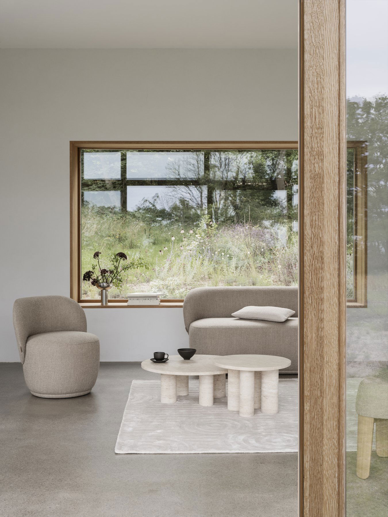 Modernes Wohnzimmer mit gemütlicher Möbel und Blick auf die grüne Landschaft draußen.