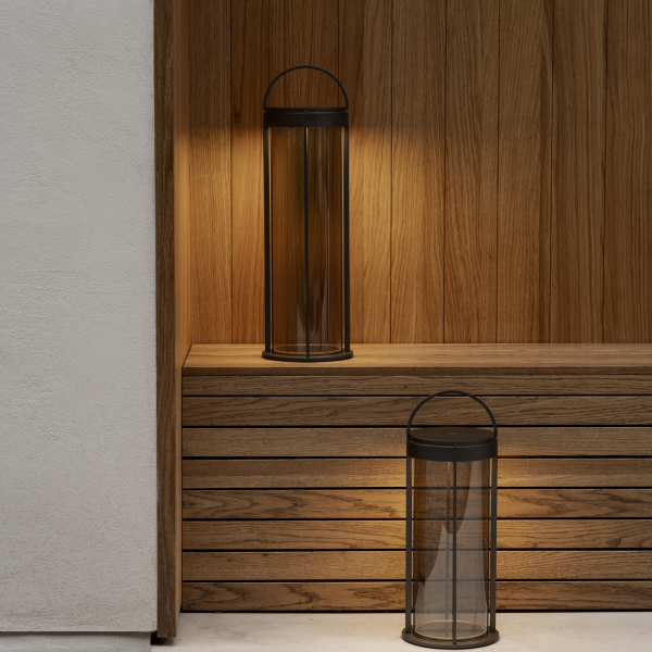 Elegante Glaslaternen auf einem Holzregal, die eine warme, moderne Atmosphäre schaffen.