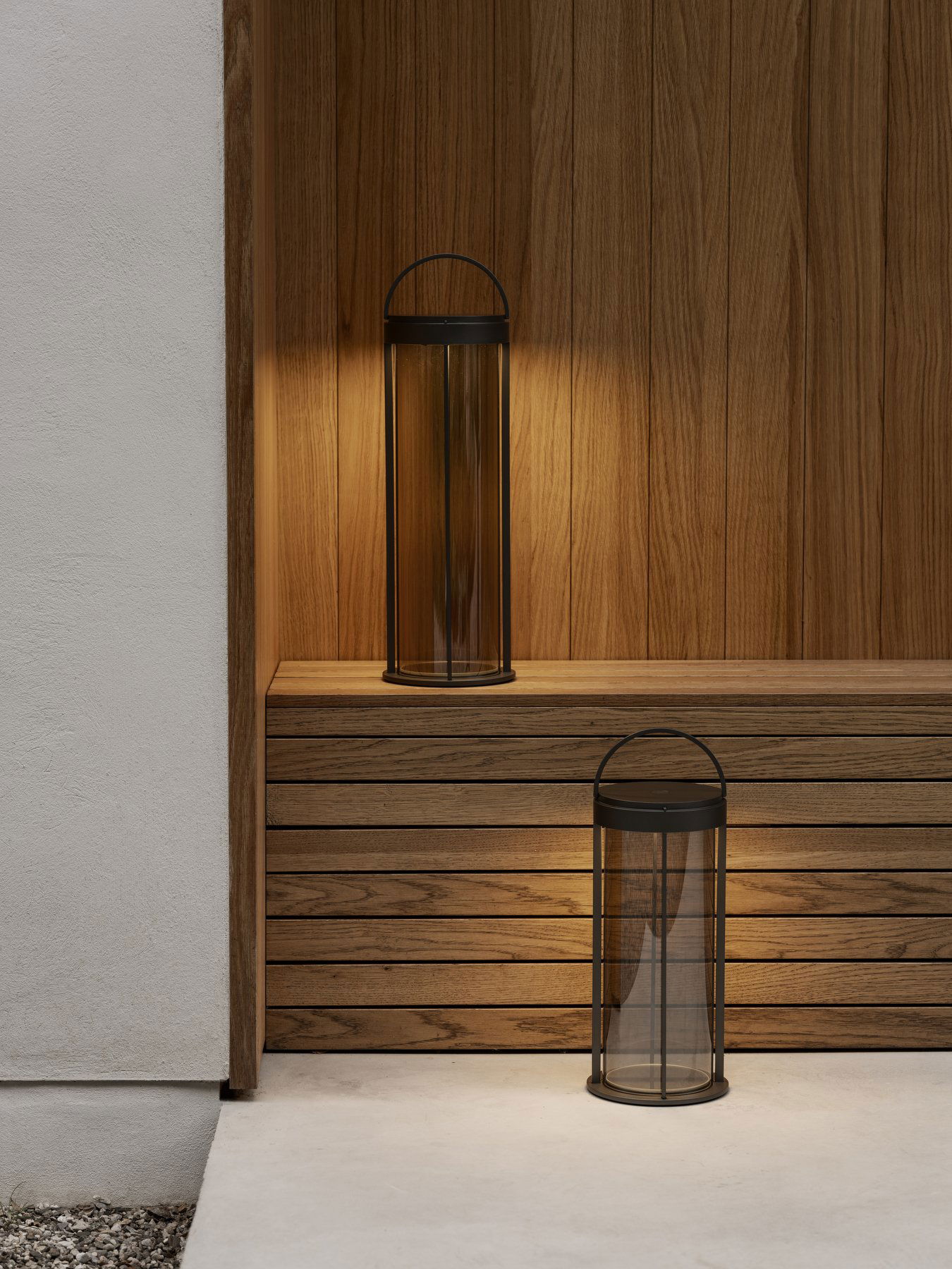 Elegante Glaslaternen auf einem Holzregal, die eine warme, moderne Atmosphäre schaffen.