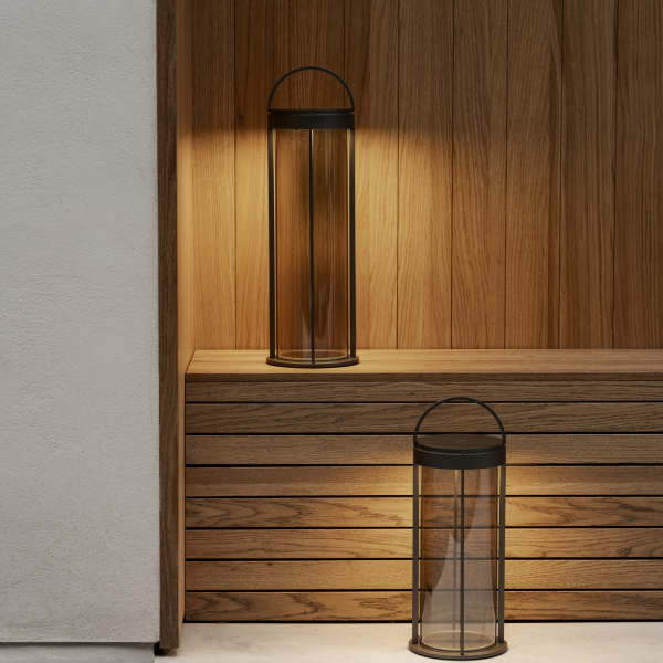 Elegante Glaslaternen mit schwarzen Akzenten, die einen Holzregal-Hintergrund beleuchten.
