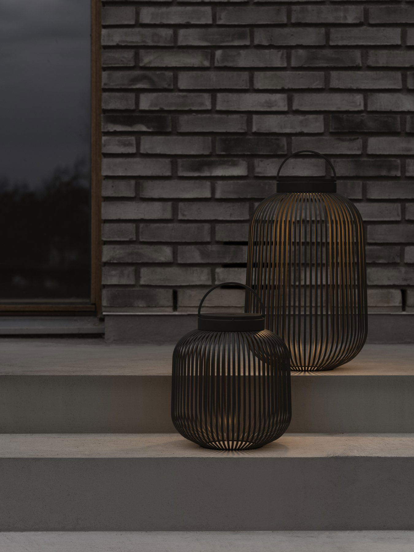 Elegante schwarze Laternen erhellen die Stufen vor einer strukturierten Backsteinmauer.