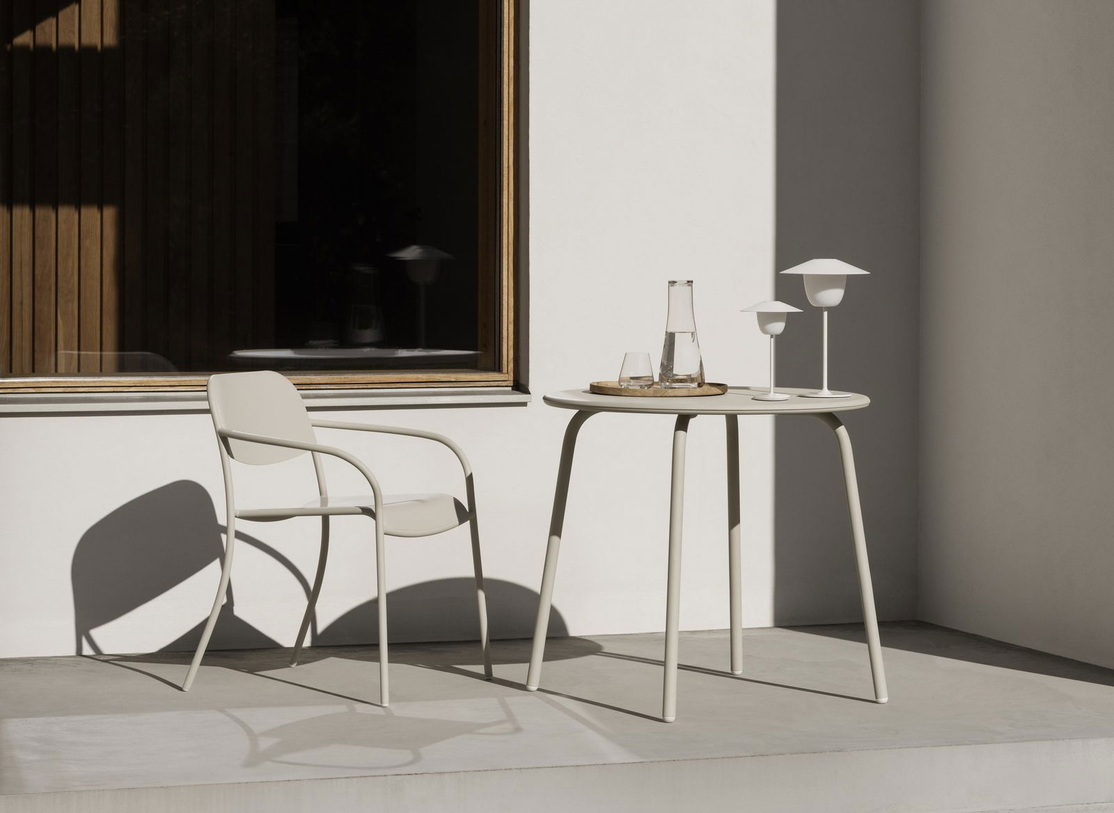 Stylish outdoor setting with a table, chair, and minimalist decor in natural light.