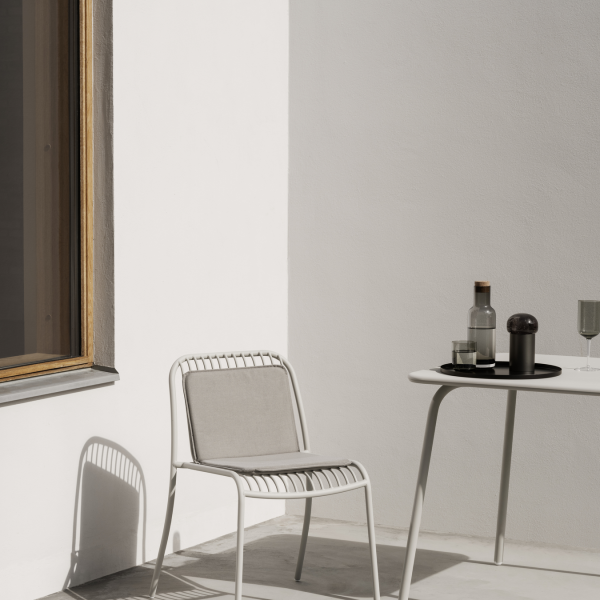 Moderne minimalistische Außenmöbel mit einem weißen Stuhl und einem stilvollen Tisch.