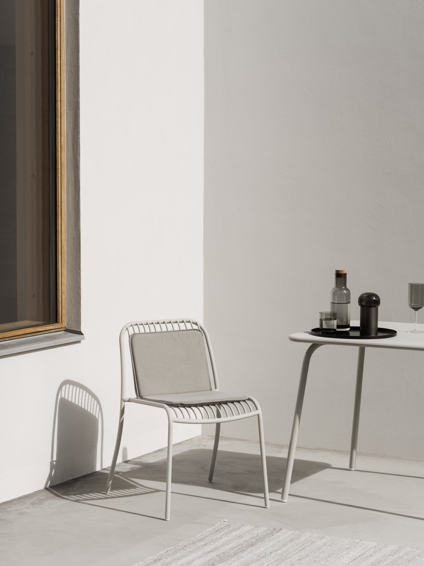 Moderne minimalistische Außenmöbel mit einem weißen Stuhl und einem stilvollen Tisch.