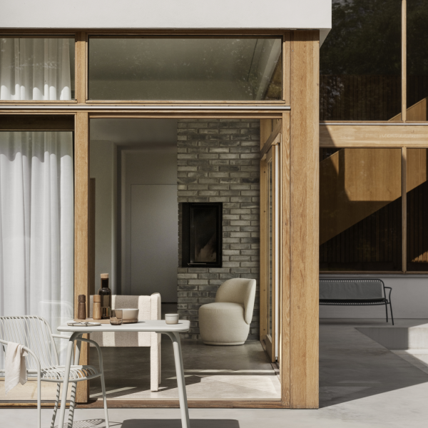 Moderne Außenterrasse mit stilvollen Möbeln und großen Glastüren, die ein gemütliches Interieur präsentieren.