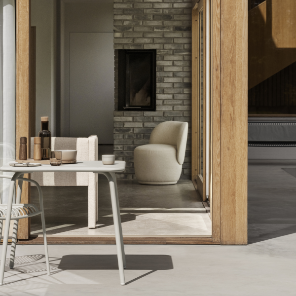 Stilvolles modernes Interieur mit einem Tisch, Champagner und gemütlichen Sitzgelegenheiten in einer natürlich beleuchteten Umgebung.