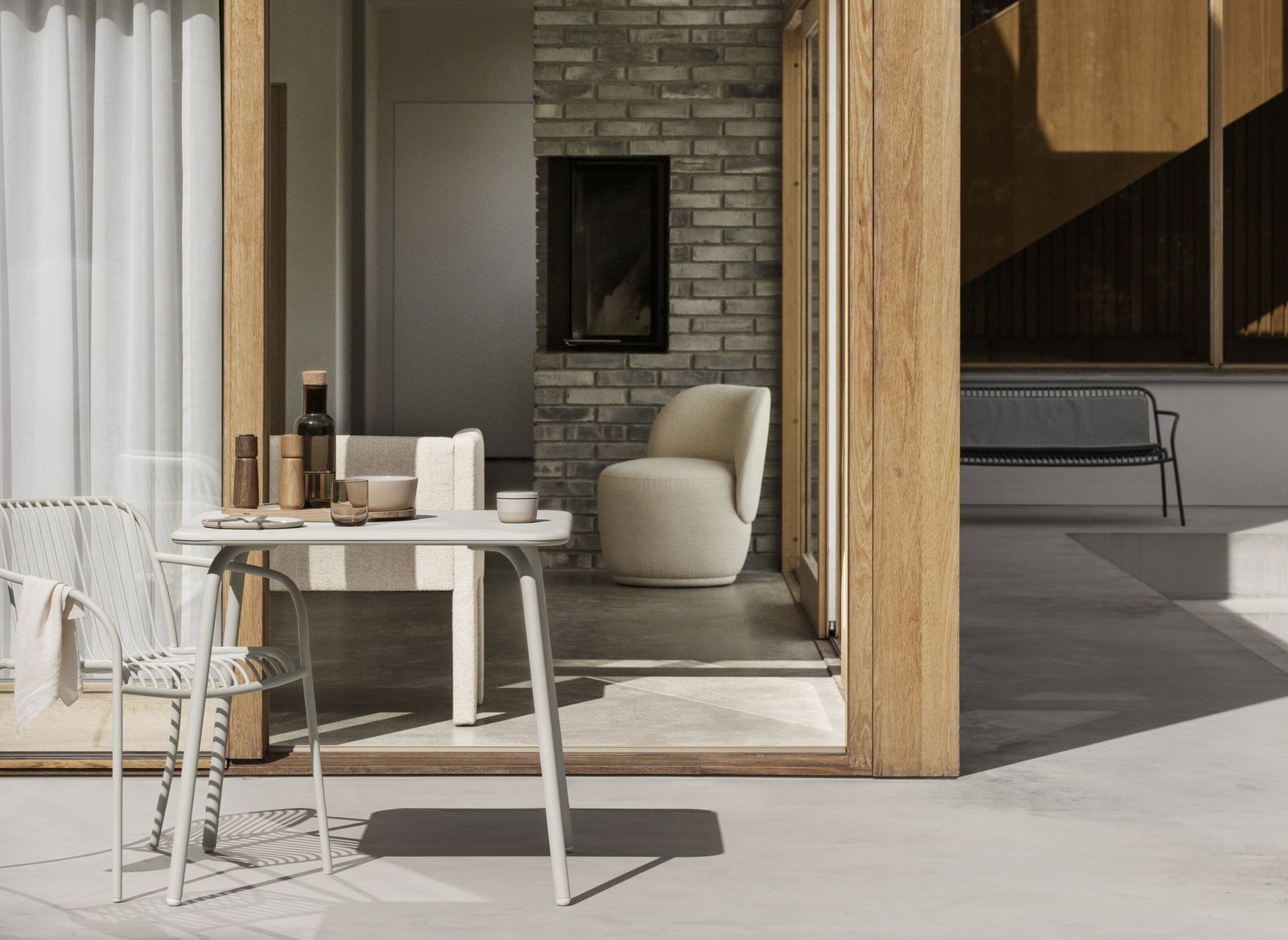 Stilvolles modernes Interieur mit einem Tisch, Champagner und gemütlichen Sitzgelegenheiten in einer natürlich beleuchteten Umgebung.