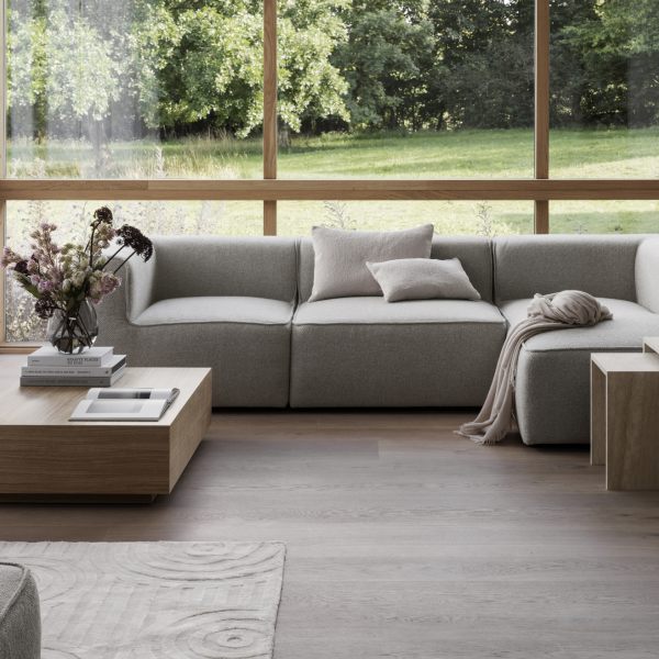 Geräumiges modernes Wohnzimmer mit großen Fenstern, neutraler Möbeln und natürlichem Licht.