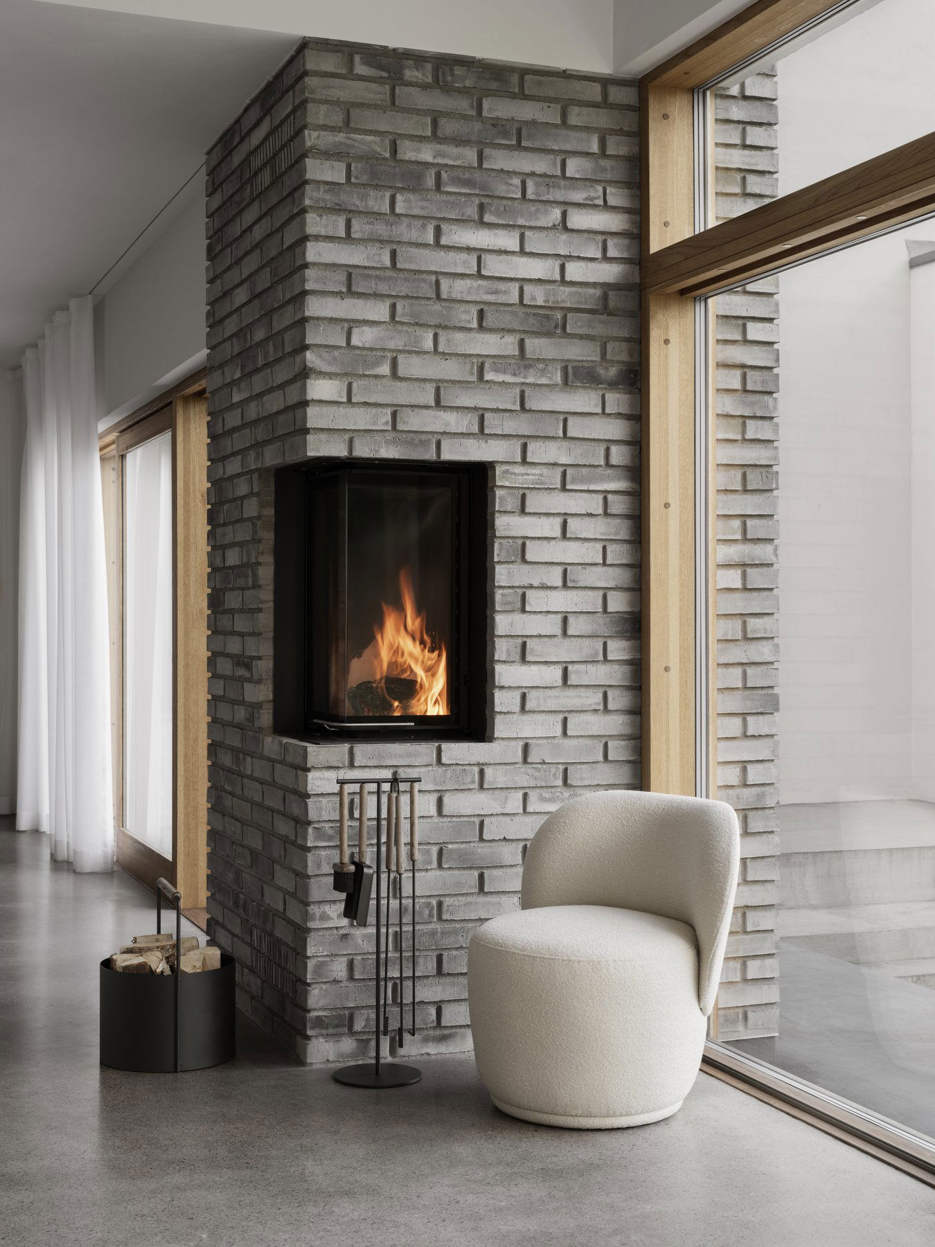 Moderner Wohnraum mit einem gemütlichen Kamin und minimalistischem Dekor, der einen stilvollen Stuhl beinhaltet.