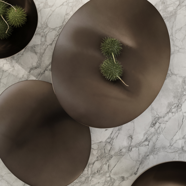 Elegant dark bowls with green accents on a marble surface, showcasing modern decor.