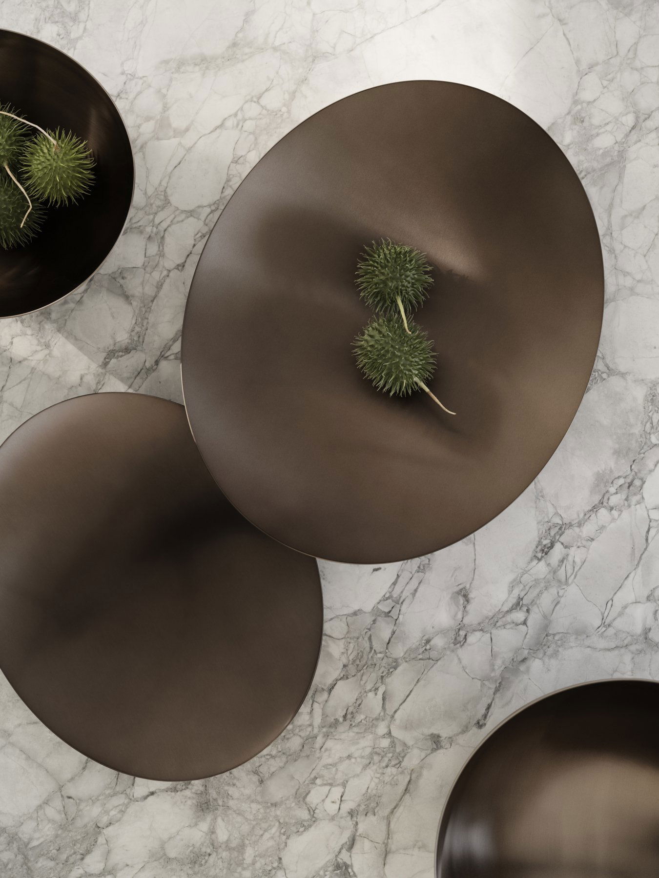 Elegant dark bowls with green accents on a marble surface, showcasing modern decor.