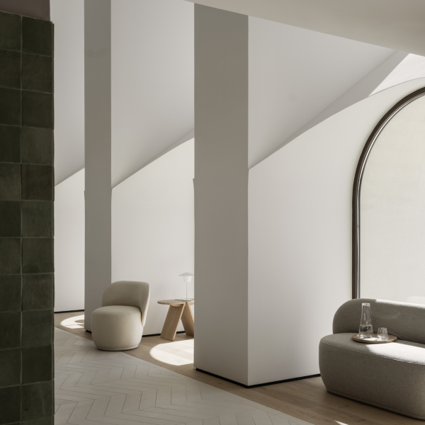 Moderner minimalistischer Innenraum mit weichen Möbeln und kantigen architektonischen Elementen.