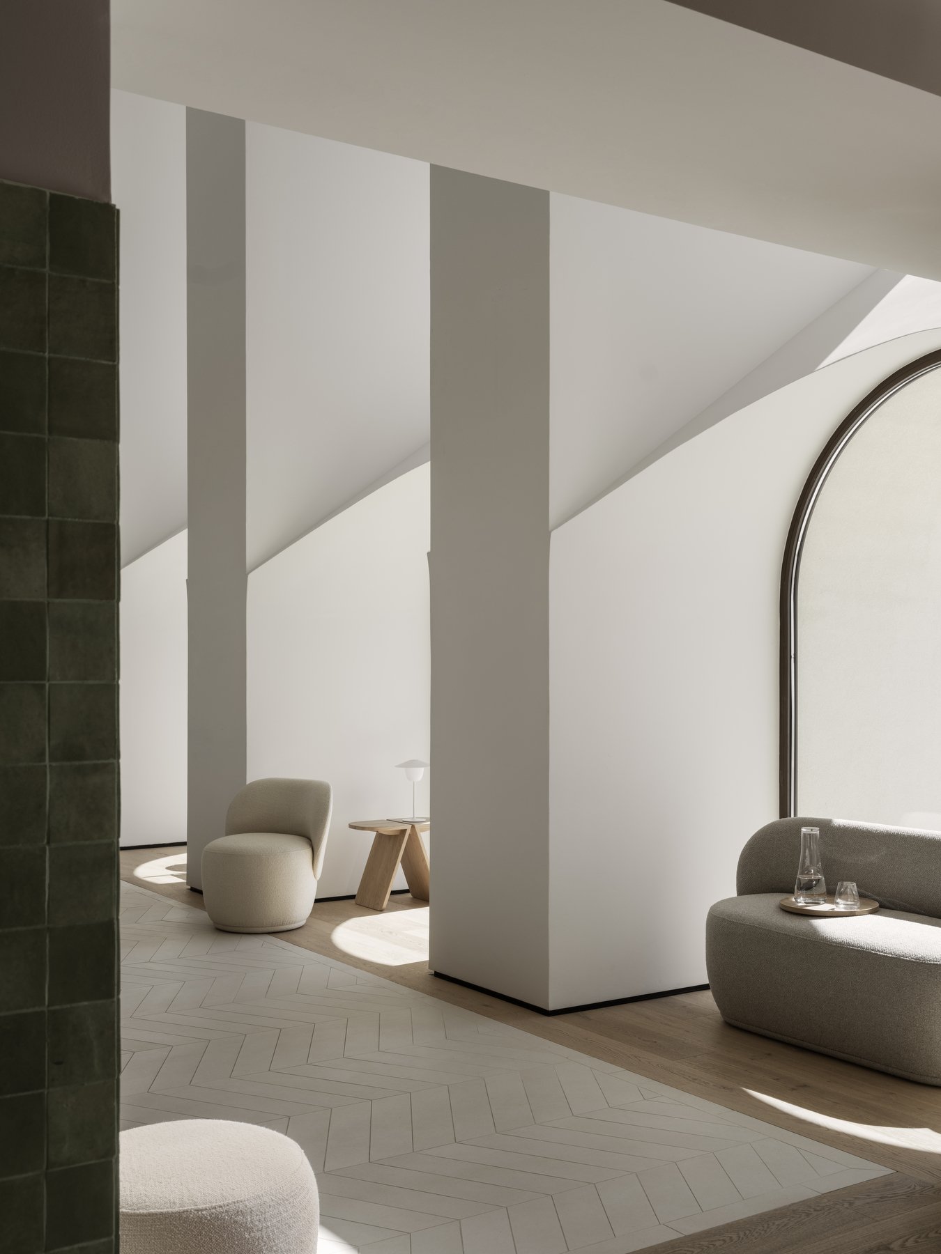Moderner minimalistischer Innenraum mit weichen Möbeln und kantigen architektonischen Elementen.