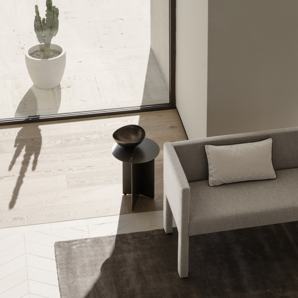 Moderne Wohnzimmerinterieur mit einem stilvollen Sofa, einem dekorativen Hocker und einer Topfpflanze.