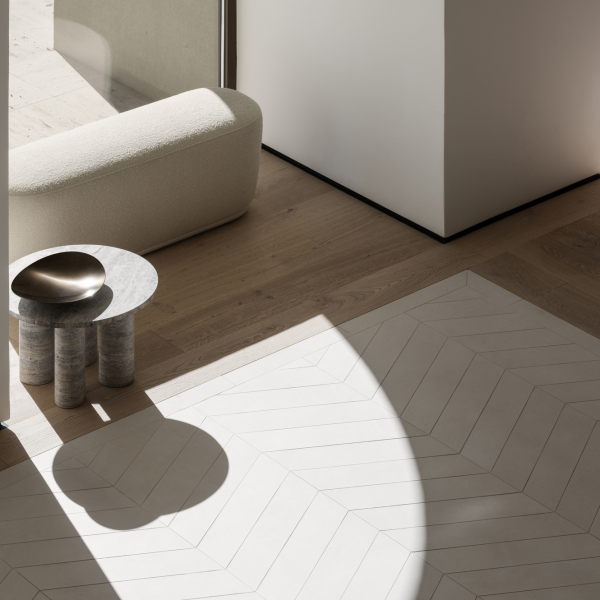 Modern minimalist Innenraum mit einem cremfarbenen Sofa, einem marmornen Beistelltisch und einem geometrischen Teppich.
