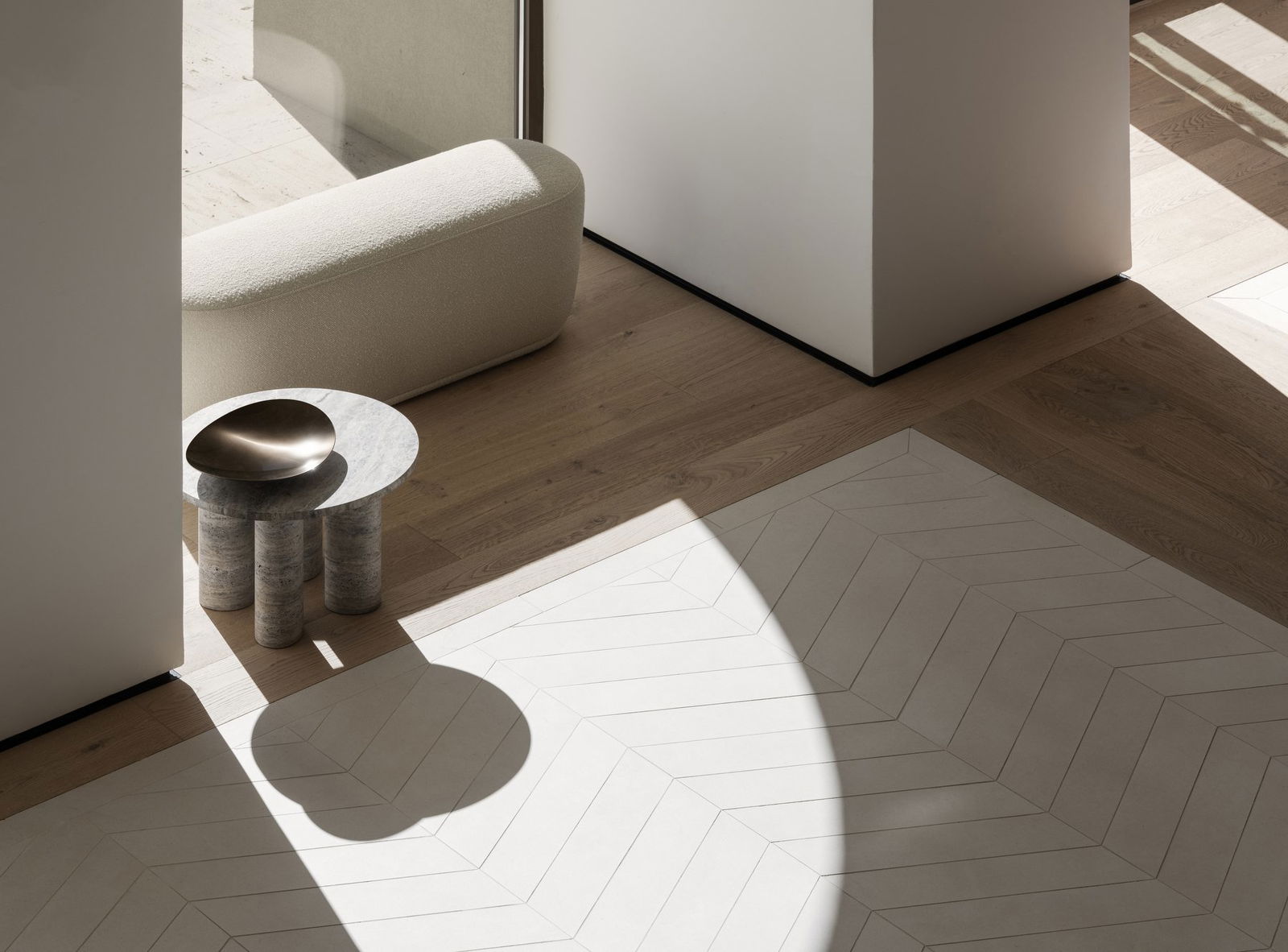 Modern minimalist Innenraum mit einem cremfarbenen Sofa, einem marmornen Beistelltisch und einem geometrischen Teppich.