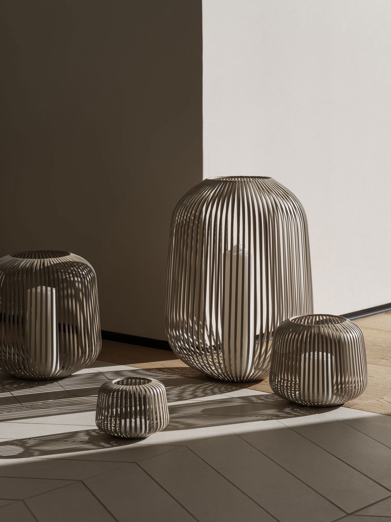 Elegante moderne Drahtvasen, die filigrane Schatten auf einem minimalistischen Boden werfen.
