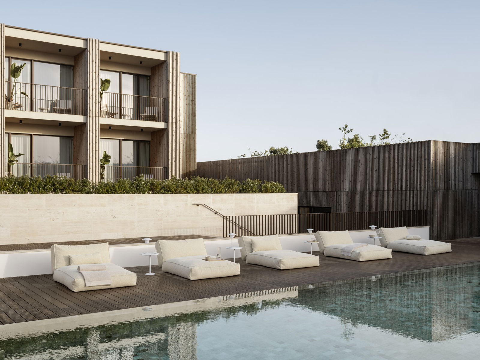 Luxurious poolside lounge area with modern sunbeds and elegant wooden architecture.