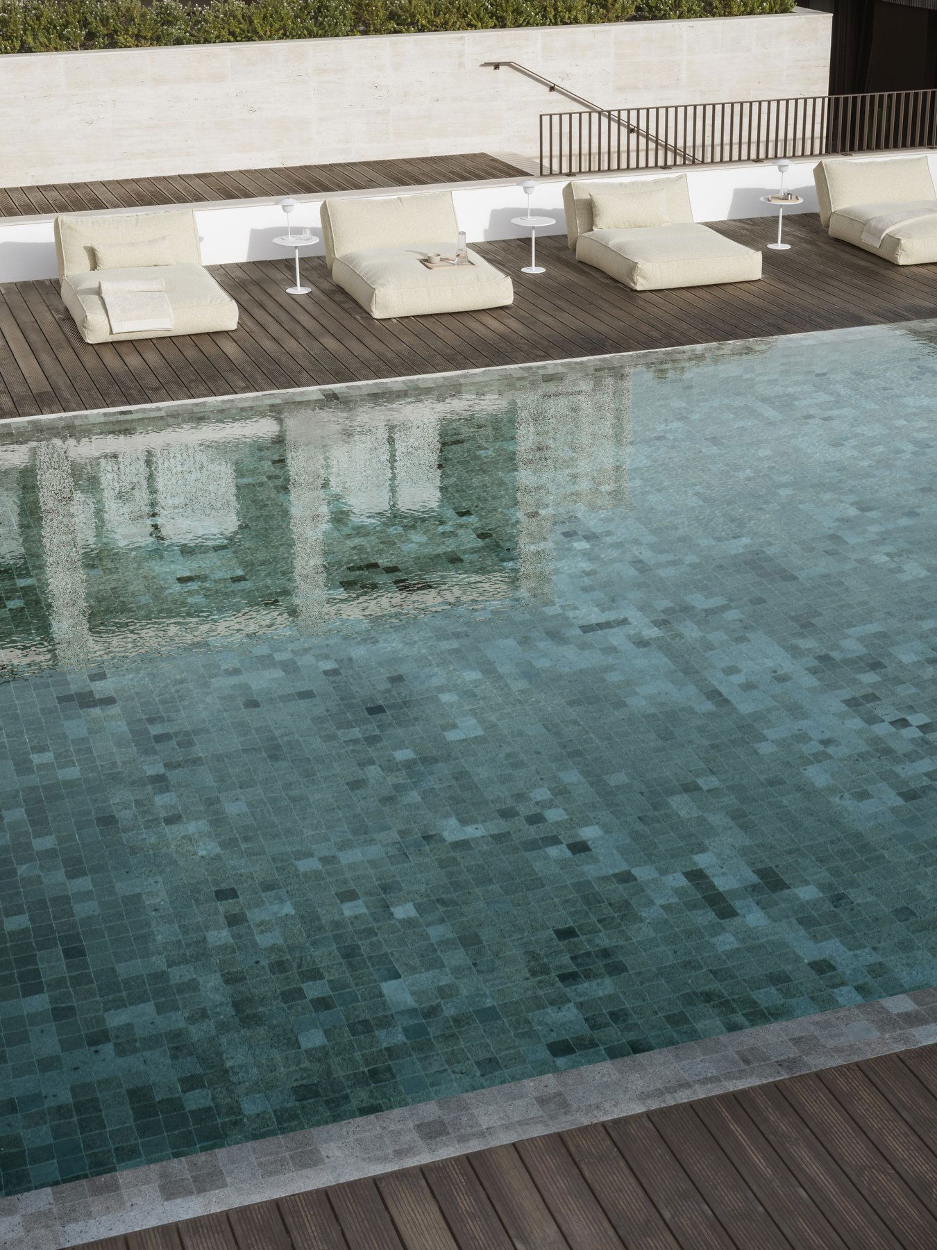Luxurious poolside with loungers and clear water reflecting a serene atmosphere.