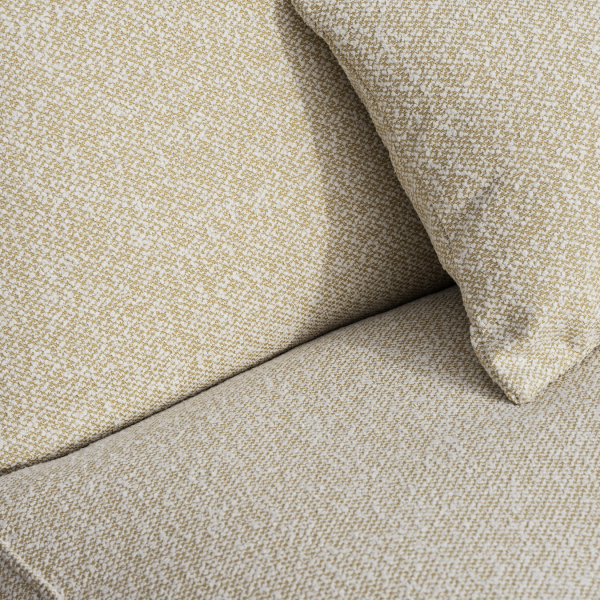 Textured beige and white fabric sofa with a decorative pillow.