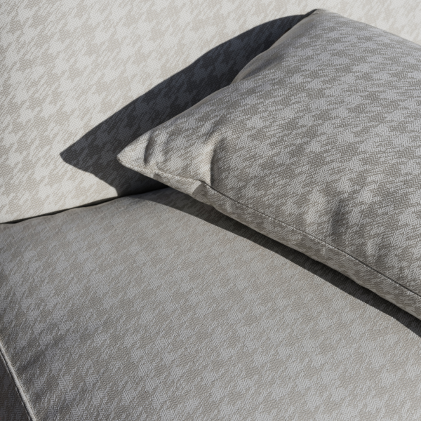 Elegant grey houndstooth patterned upholstery featuring a soft matching pillow.