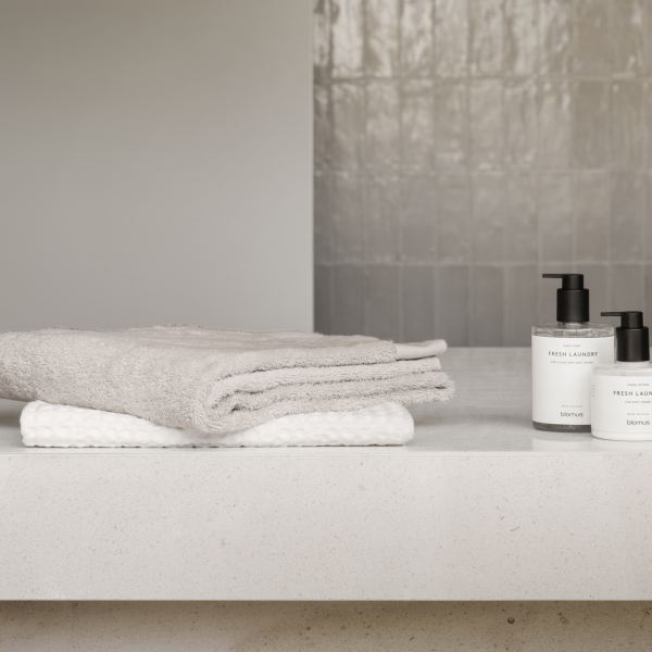 Soft towels and fresh laundry products displayed on a clean bathroom countertop.