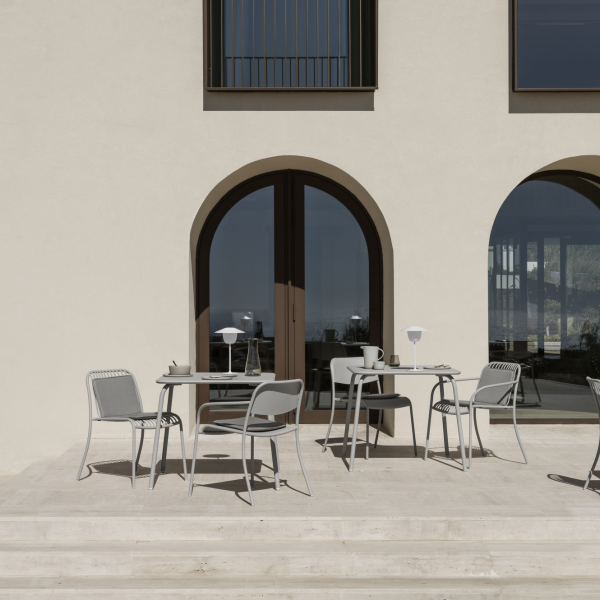 Modern outdoor patio with stylish gray furniture and elegant arches, perfect for dining.