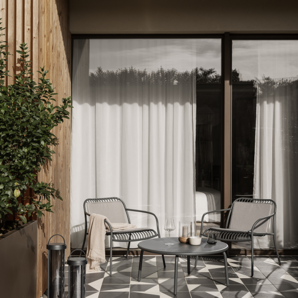Moderner Patio mit stilvollen Stühlen und einem Tisch, der elegantes Dekor und natürliches Licht bietet.