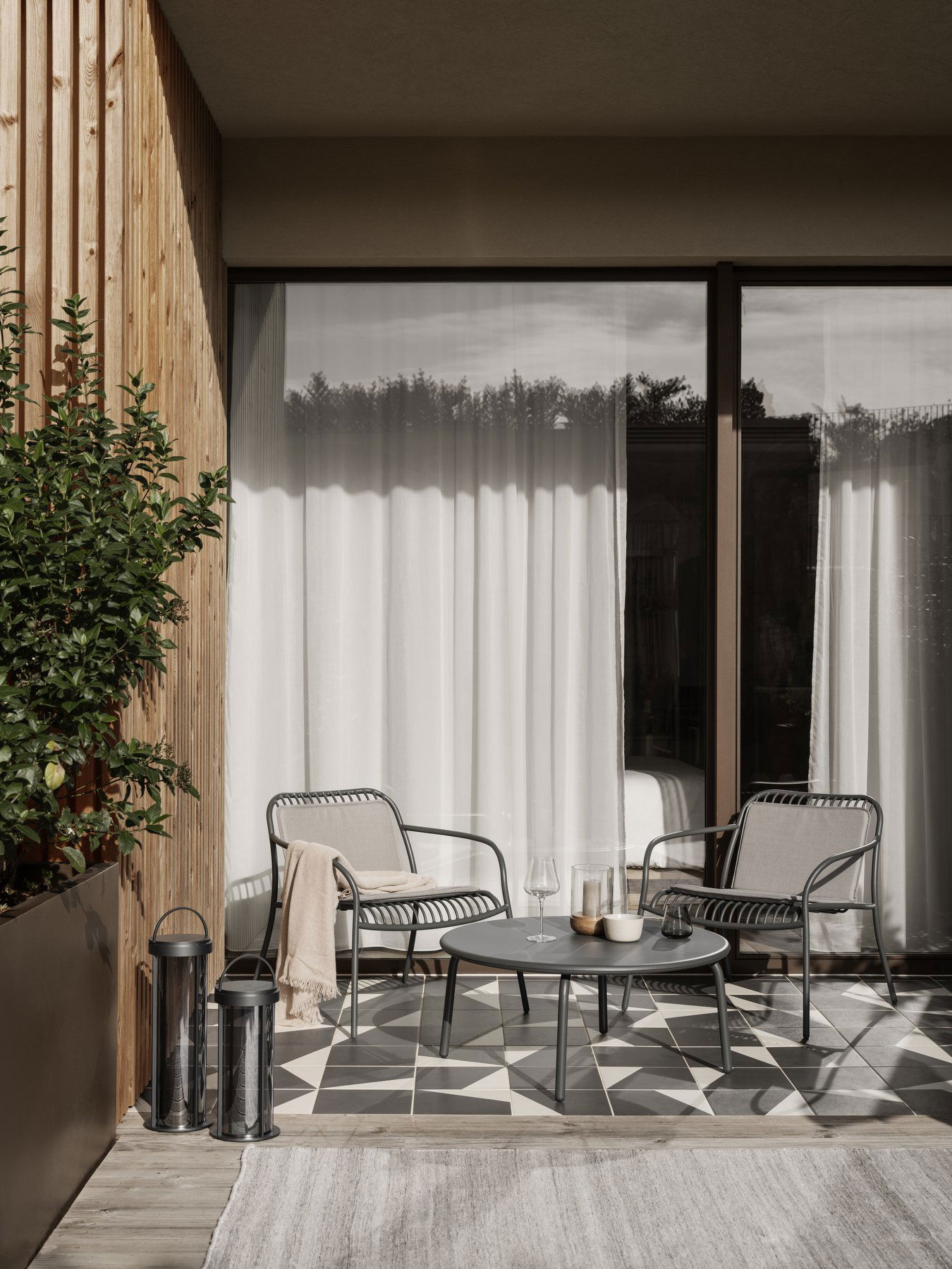 Moderner Patio mit stilvollen Stühlen und einem Tisch, der elegantes Dekor und natürliches Licht bietet.