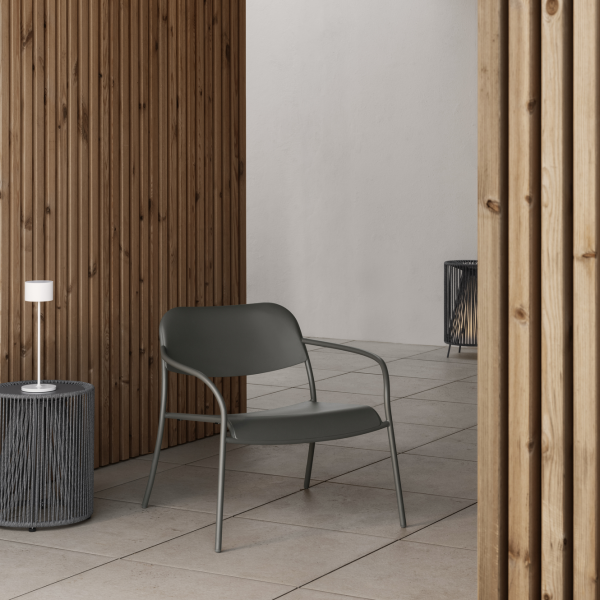 Modern outdoor chair in a minimalist setting with wooden walls and stylish lighting.