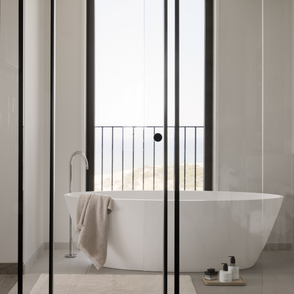 Modernes Badezimmer mit freistehender Badewanne und einer malerischen Aussicht durch große Fenster.