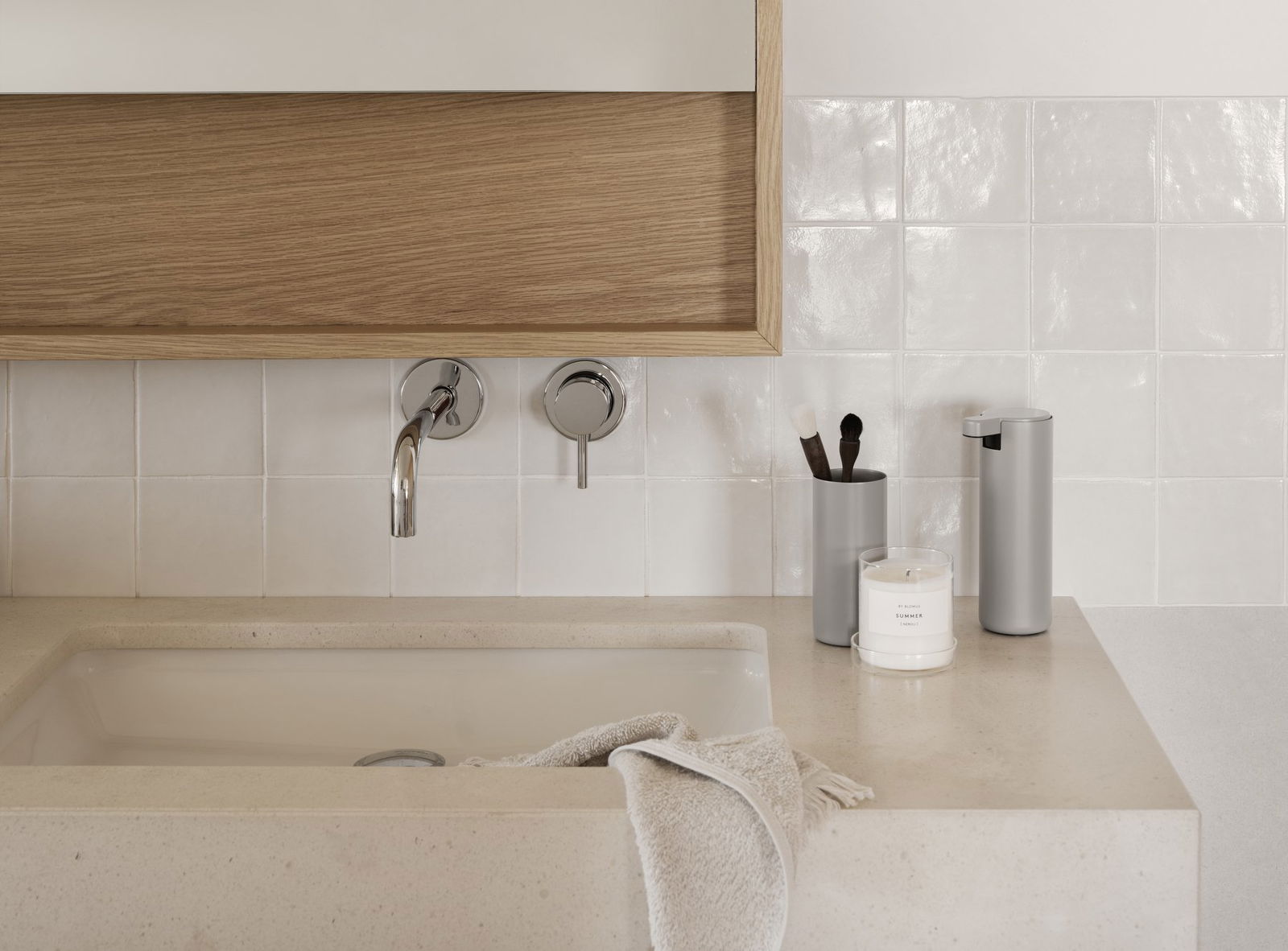 Moderner Badezimmerwaschtisch mit eleganten Armaturen, dekorativen Accessoires und sanften neutralen Farben.