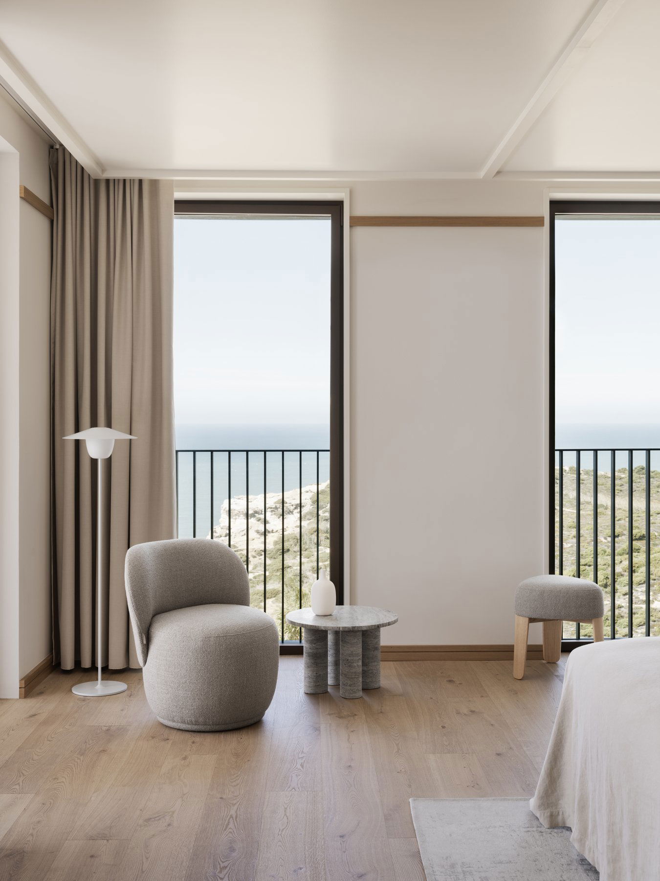 Modernes Küsteninterieur mit einem stilvollen Stuhl, Lampen und malerischem Meerblick.