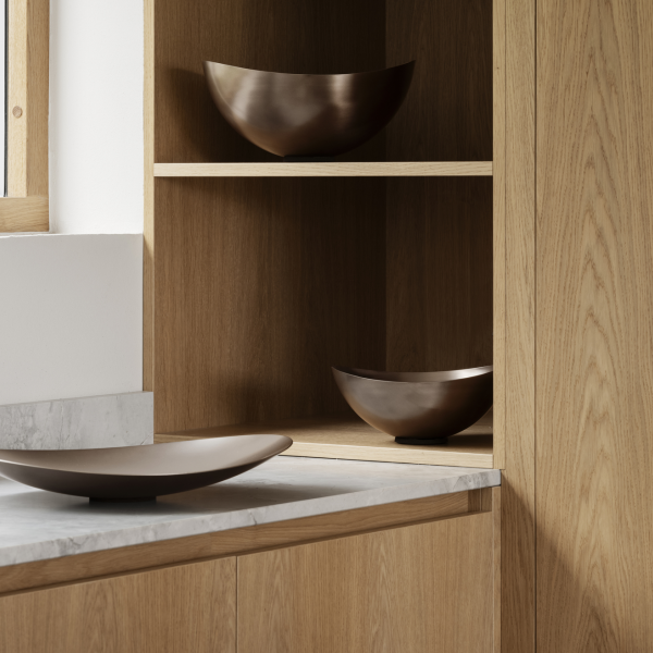 Elegante Holzschränke mit stilvollen Metalltellern, die in einer modernen Küchenumgebung ausgestellt sind.
