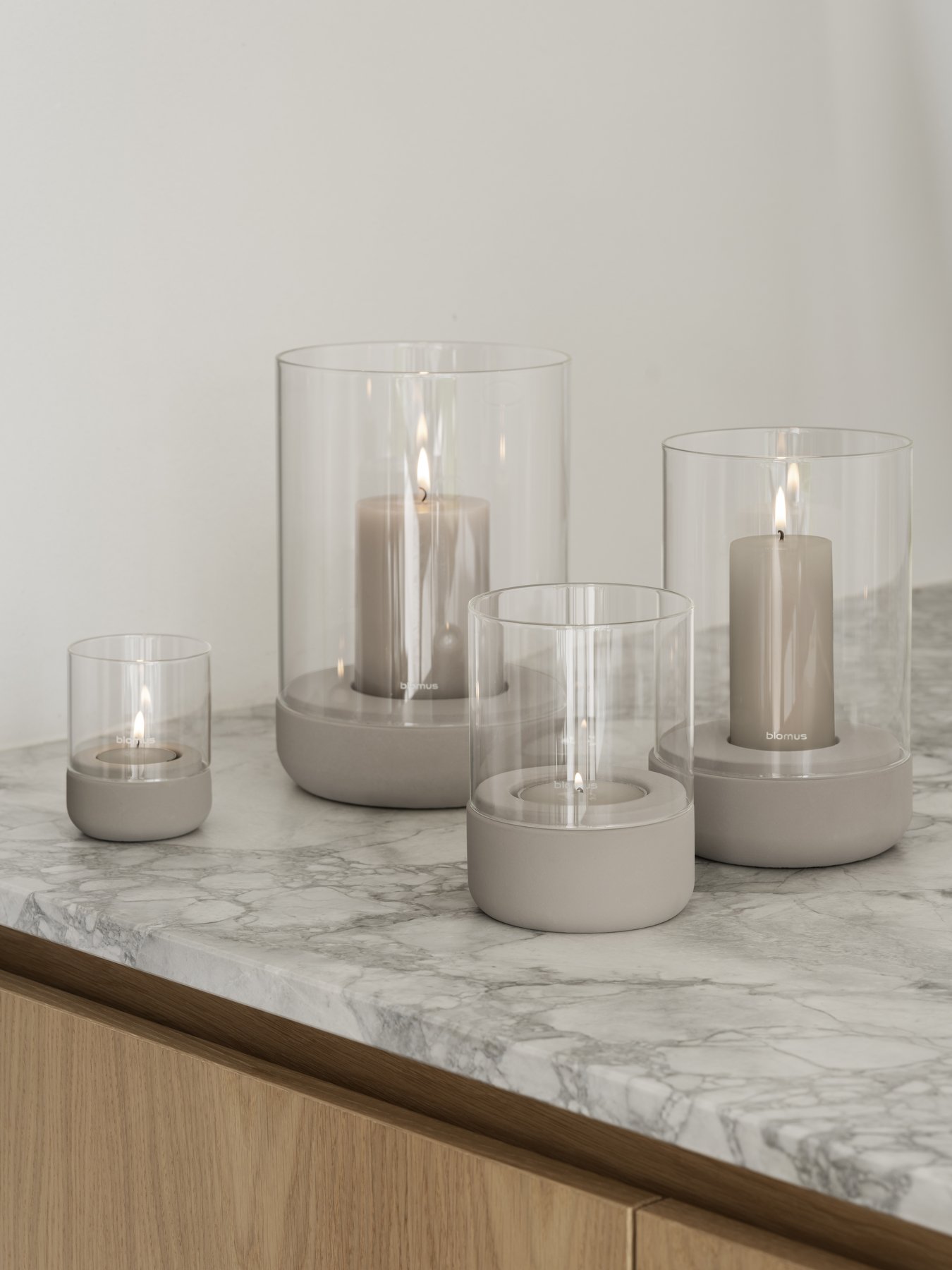 Elegant candle display in glass holders on a stylish marble countertop.