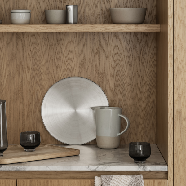 Sleek kitchen display featuring modern tableware and minimalist decor on wooden shelves.