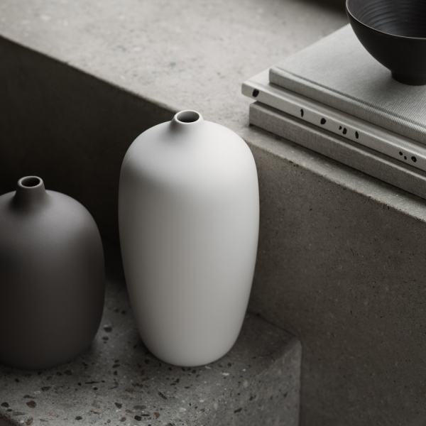 Minimalistische Keramikvasen in neutralen Tönen auf einer strukturierten Oberfläche, die moderne Dekoration betonen.