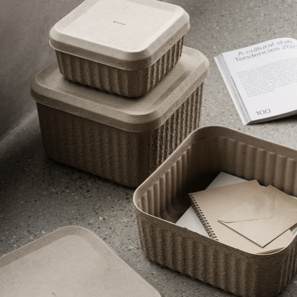 Stylische umweltfreundliche Aufbewahrungsboxen auf einer modernen Arbeitsplatte mit einer nahegelegenen Zeitschrift.