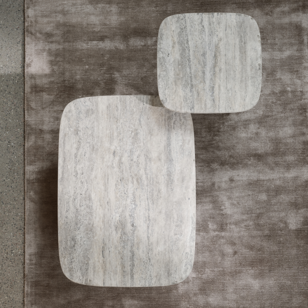 Stylish marble coffee tables on a textured rug for modern interior design.
