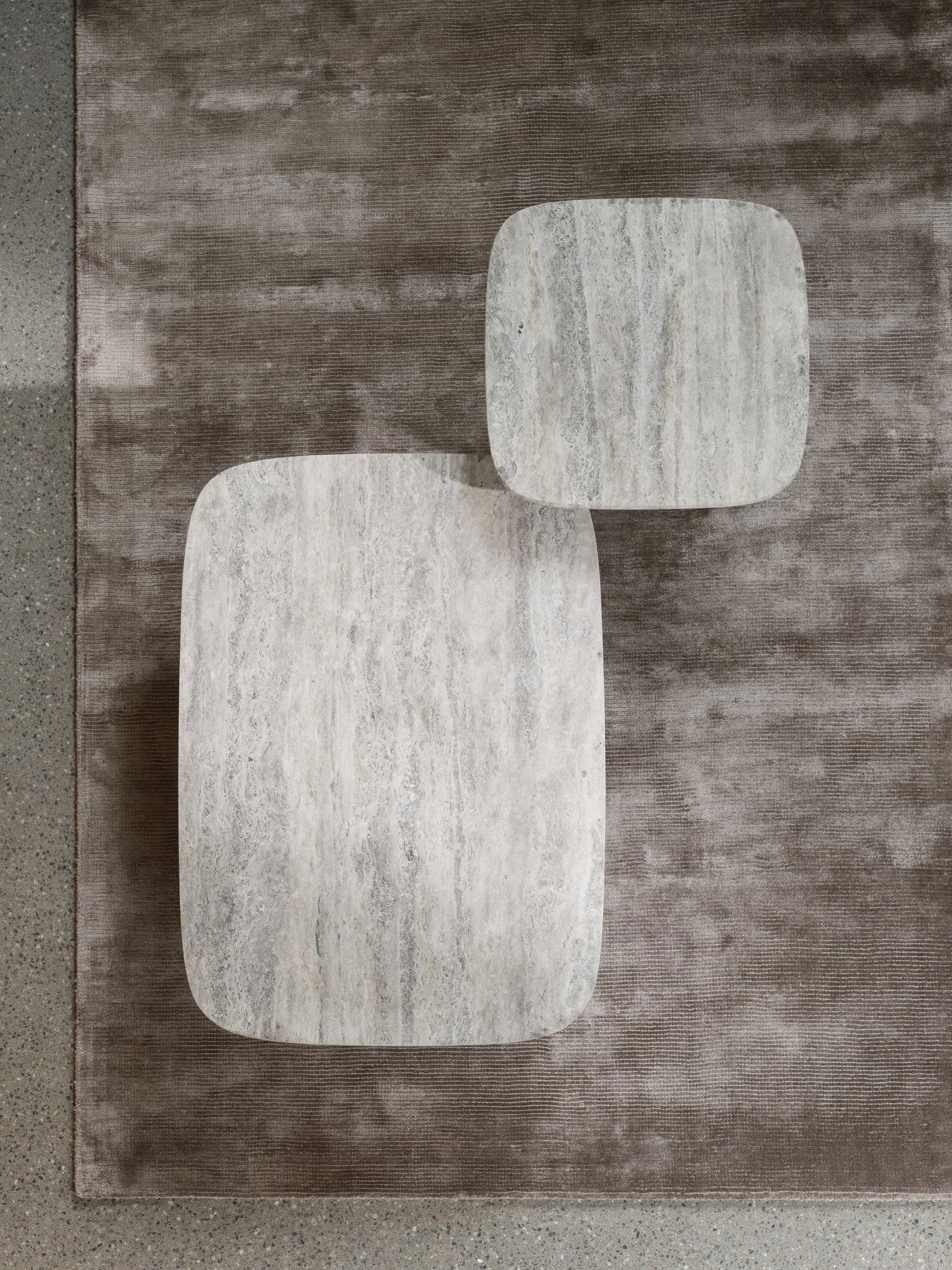 Stylish marble coffee tables on a textured rug for modern interior design.