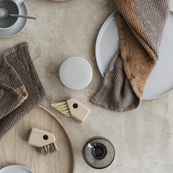 "Elegante Tischdekoration mit minimalistischen Geschirr, Besteck und strukturierten Tischdecken für modernes Essen."