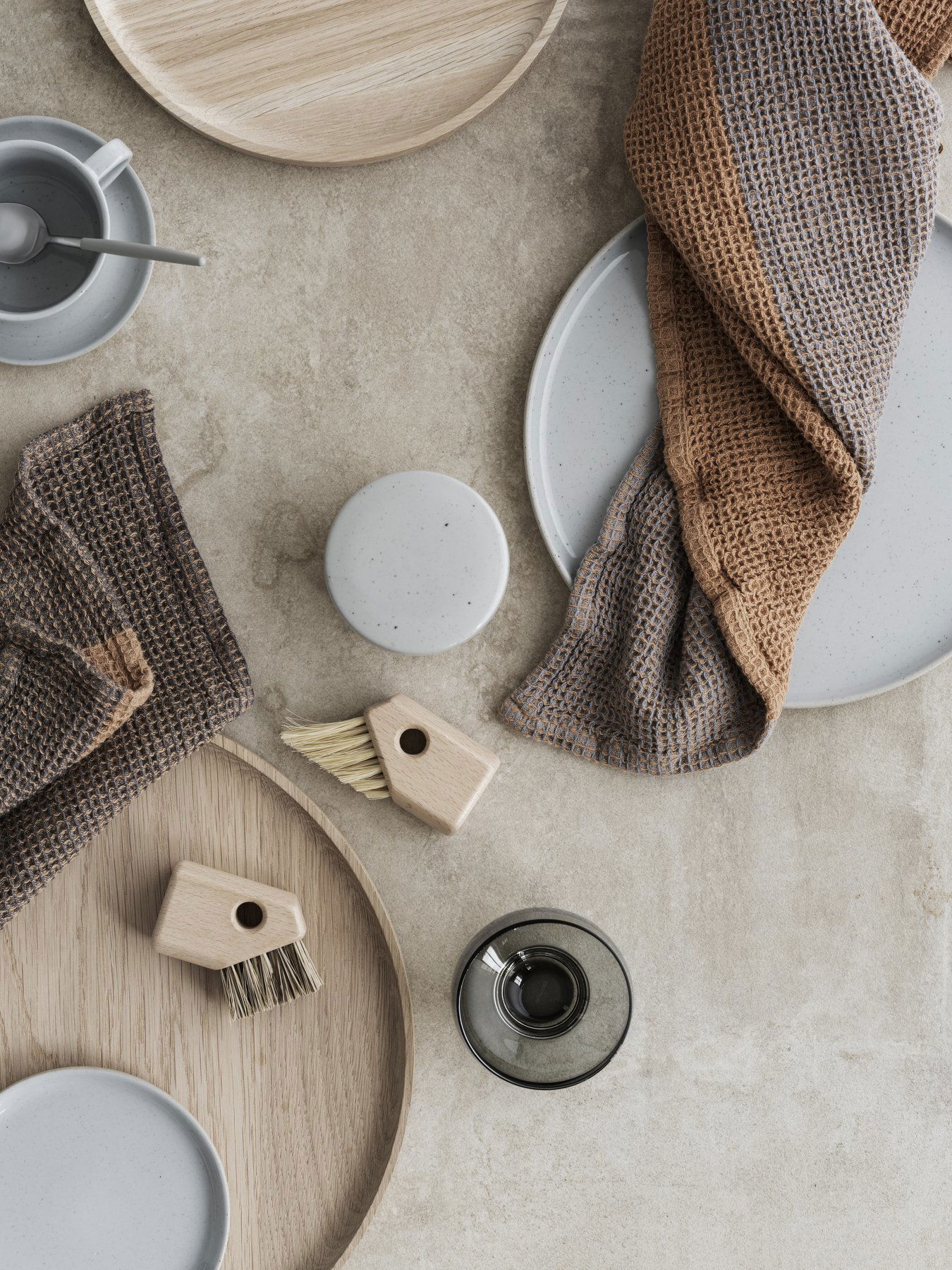 "Elegante Tischdekoration mit minimalistischen Geschirr, Besteck und strukturierten Tischdecken für modernes Essen."