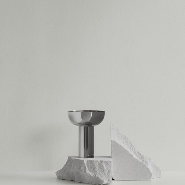 Stylische moderne Vase auf einem strukturierten Steindisplay vor einer minimalistischen hellgrünen Wand.