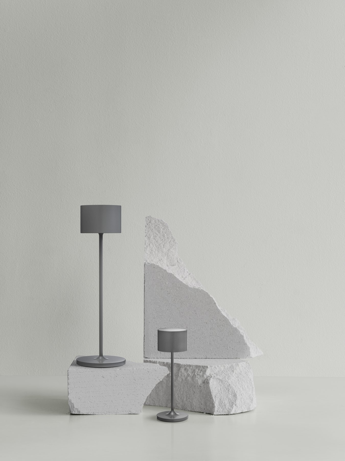 Modern table lamps on abstract geometric stone bases against a minimalist wall.